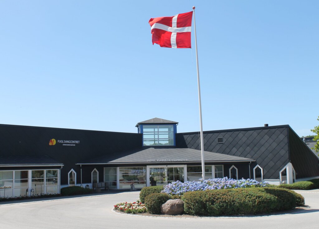 Indgangen til Fuglsangcentret set forfra med blomster og Dannebrog på helt.