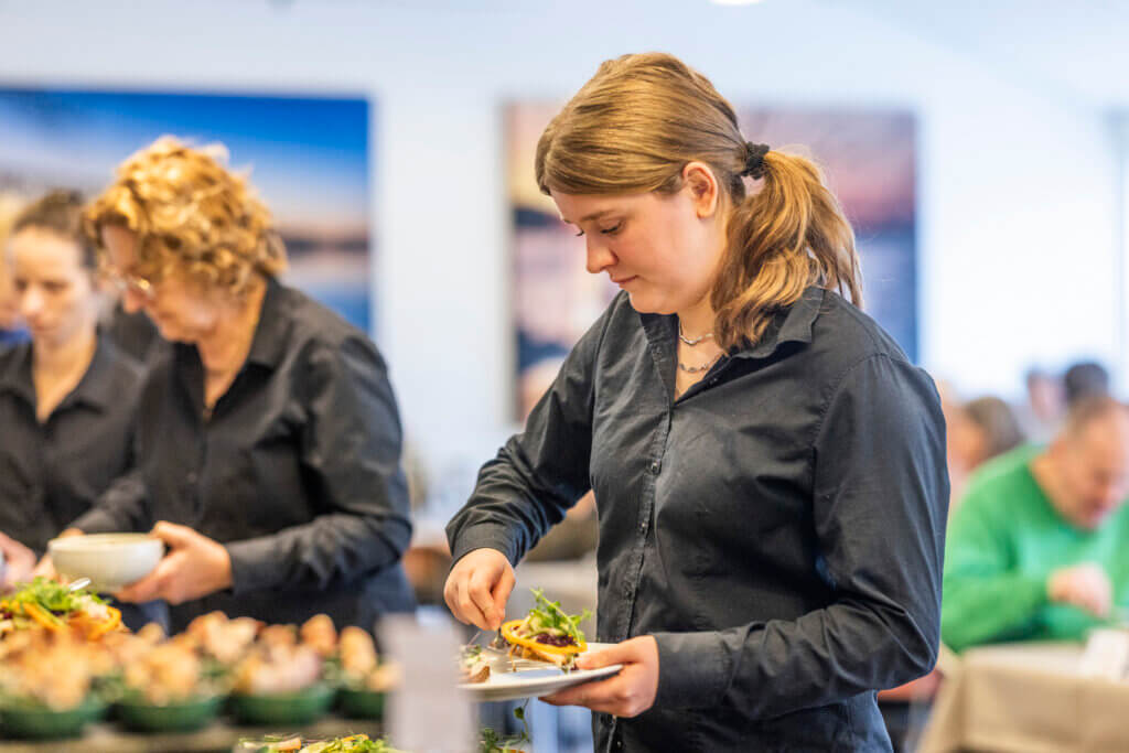 Tjener ved buffeten, der er ved at anrette en tallerken