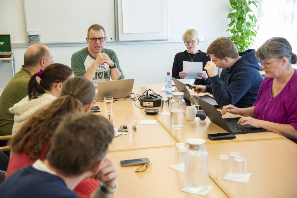 en gruppe mennesker sidder om en bord i et af grupperummene